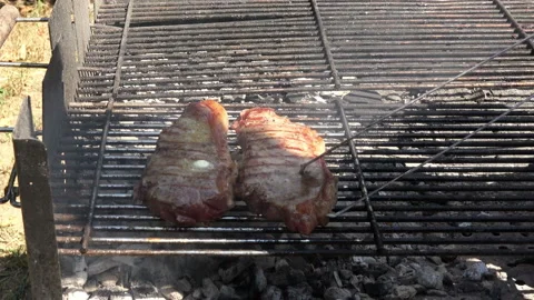 Turning a beef steak on the grill 4K Stock Footage 130797705