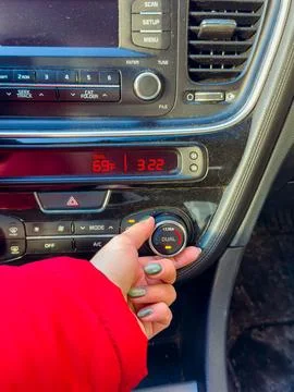 Turning the climate control dial in a car to adjust temperature while insid.. Foto stock