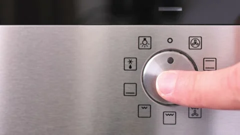 Turning cooking mode switch on an electric oven. Male hand turns on the oven Stockbeeldmateriaal 204900175