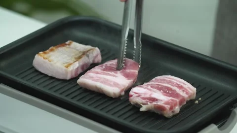 Turning Crispy Pork Belly in Heated Pan Stock Footage 334828422