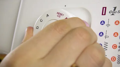 Turning the dial to select patterns on the sewing machine. Stock Footage 139200613