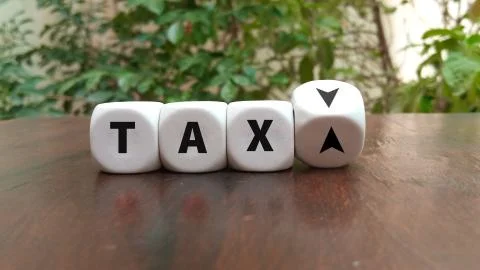 Turning a dice and changes the direction of an arrow symbolizing that the Tax Stock Photos
