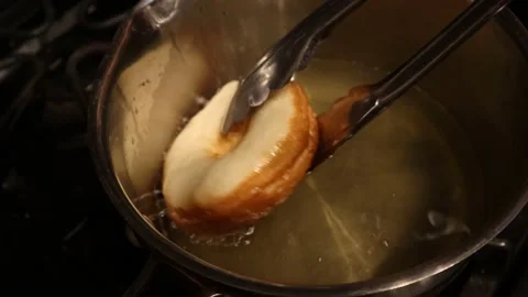 Turning a donut in a pan Stock Footage 135705293