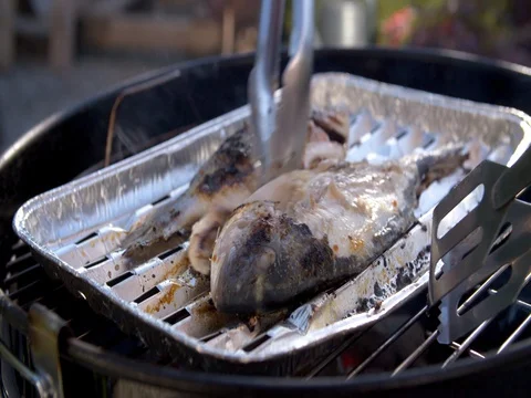 Turning fresh rainbow trout fish being grilled on a barbecue Stock Footage 77201588