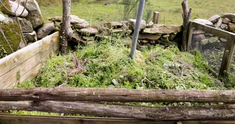 Turning green waste in a rustic compost bin Stock Footage 333251200