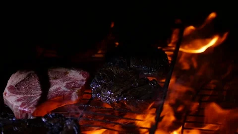 Turning grilling meat on a barbecue using metal tongs Stock Footage 153520980