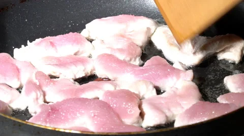 Turning half-cooked meat pieces on a pan Stock Footage 61440629