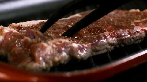 Turning half cooked steak on the grill 스톡 동영상 102611206