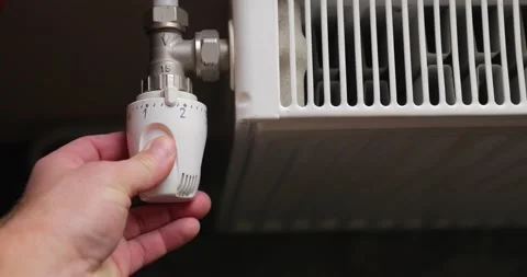 Turning heating valve adjusting radiator Stock Footage 140957416