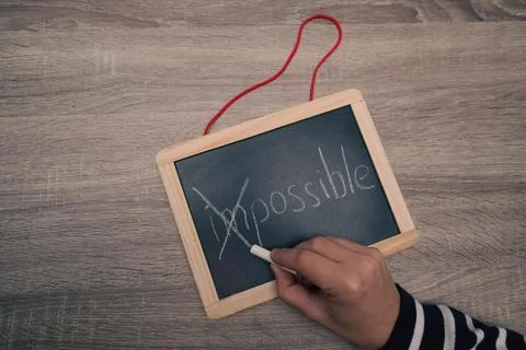 Turning the impossible into the possible. Impossible written with white cha.. Stock Photos