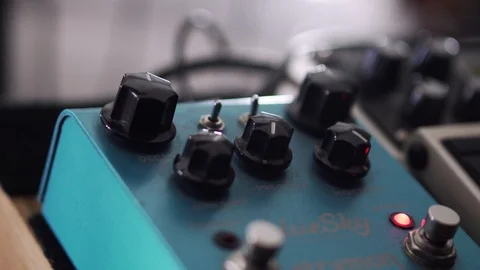Turning knobs and flipping switches on a guitar effects pedal 動画素材 93716190