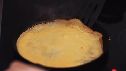 Turning a large and thin pancake in a pan for roasting the other side Stock Footage 112017623
