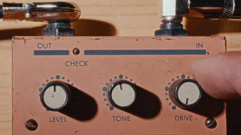 Turning Level, Tone and Drive Knobs on Vintage Guitar Effects Pedal Stock-Footage 342454493