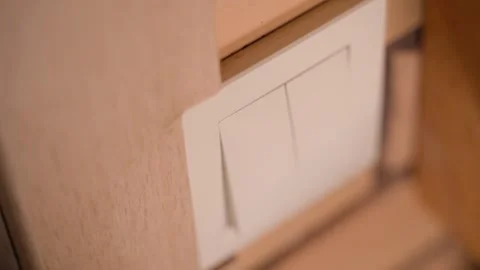Turning the light on and off with a wall switch, close-up Stock Footage 324698044