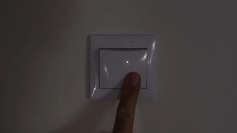 Turning off the light with a light switch in a room. A person turning off the Video stock 220351650