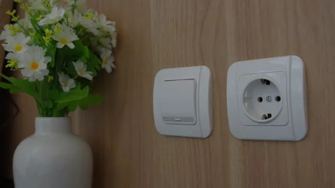 Turning a light switch on and off, demonstrating energy conservation Stock Footage 339196999