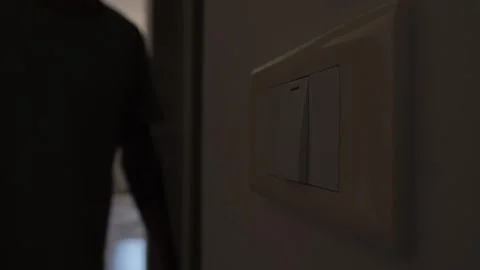 Turning off lights at home, close up of hand pressing wall light switch to save Stock Footage 346243282