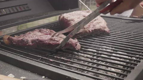 Turning the meat on the grill Video stock 138540109