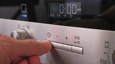 Turning on the mode switch and setting the time on electric oven. Male hand Stockbeeldmateriaal 201152925