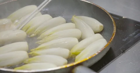 Turning over baking endives in pan restaurant kitchen Video stock 72437128