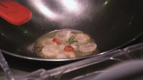 Turning over sizzling prawns in a pan Stock Footage 65560004