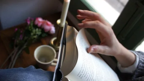 Turning Page In Book While Having Tea With A Lit Candle Stock Footage 97126955