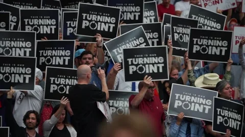 Turning Point signs are held aloft during the Charlie Kirk memorial service Stock Footage 345298081