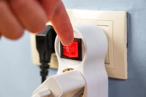 Turning off the red button of the electrical splitter to save electricity clo Stock Photos