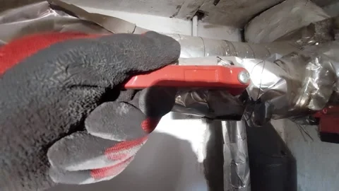 Turning a red shut-off valve on a heating system pipe Vídeos de archivo 333643705
