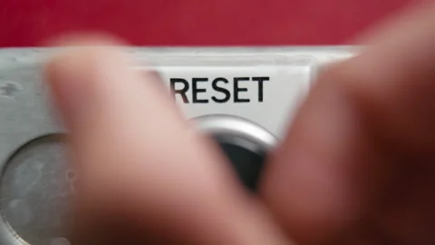 Turning a reset knob on a red wall Stock Footage 318836183
