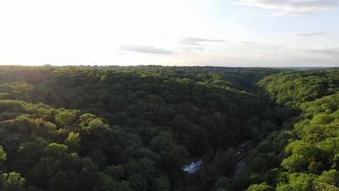 Turning right while over forest during sunset with river below Stock Footage 111345288