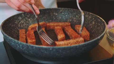 Turning roasted croutons with a fork in a pan Vídeos de archivo 252237934