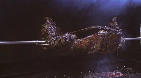 Turning roasted whole lamb Stock Footage 61730424
