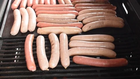 Turning sausages on a barbeque Stock-Footage 76563181