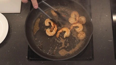 Turning seafood over in pan overhead Stock Footage 112128055