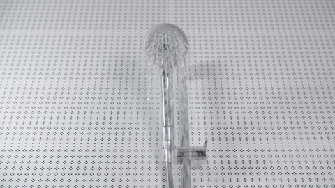 Turning on the shower head in bathroom, white tiles with black pattern Stock Footage 106092704