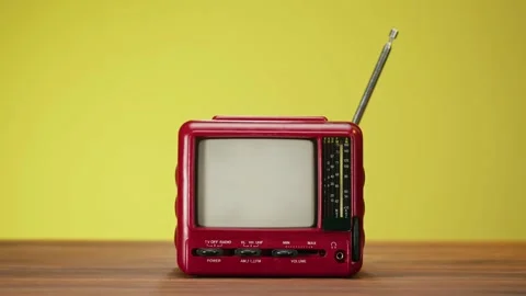 Turning on small old television with grey interference screen on yellow Stock Footage 169372980