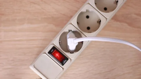 Turning socket on and inserting white cable Stock Footage 86055410