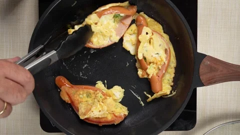 Turning Split Sausages with Cooked Egg and Green Herbs in a Pan 스톡 동영상 342803754