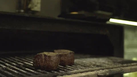 Turning a steak on the grill slow-mo Stock Footage 69781596