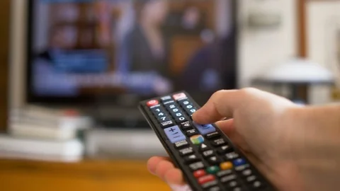 Turning on the television and scroll the channels with the remote controller Stock Footage