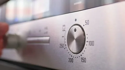 Turning the temperature switch on an electric oven. Male hand turns on the oven Stockbeeldmateriaal 201152878