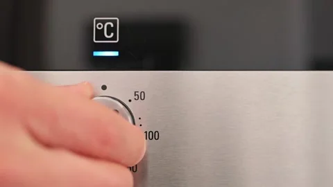 Turning the temperature switch on an electric oven. Male hand turns on the oven Stock Footage 201152902