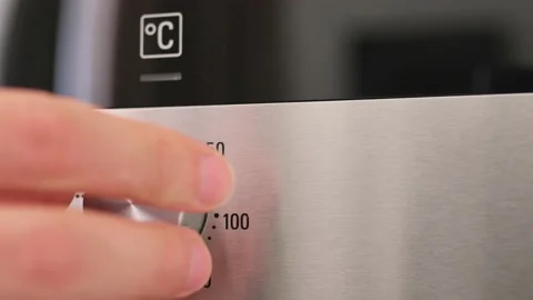 Turning the temperature switch on an electric oven. Male hand turns on the oven 動画素材 204900264
