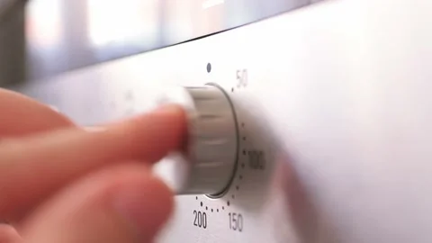 Turning the temperature switch on an electric oven. Male hand turns on the oven Stock Footage 217954352