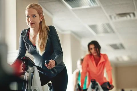 Turning up the tempo in spinning class. Working out in the gymShot of a young Stock Photos