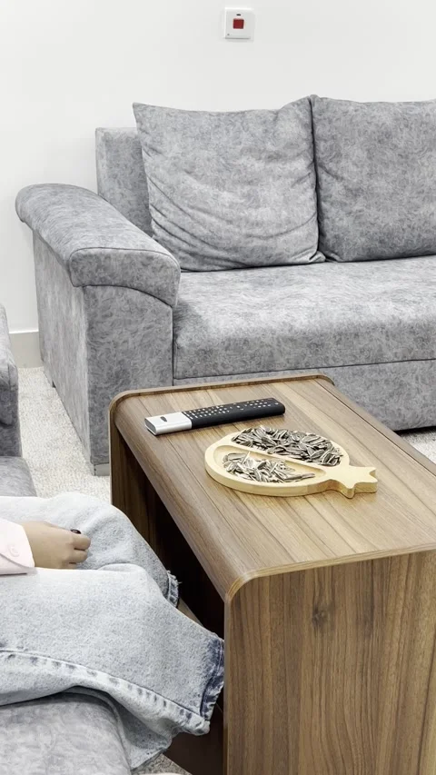 Turning on TV with remote control while eating sunflower seeds, vertical Stock Footage 345153930