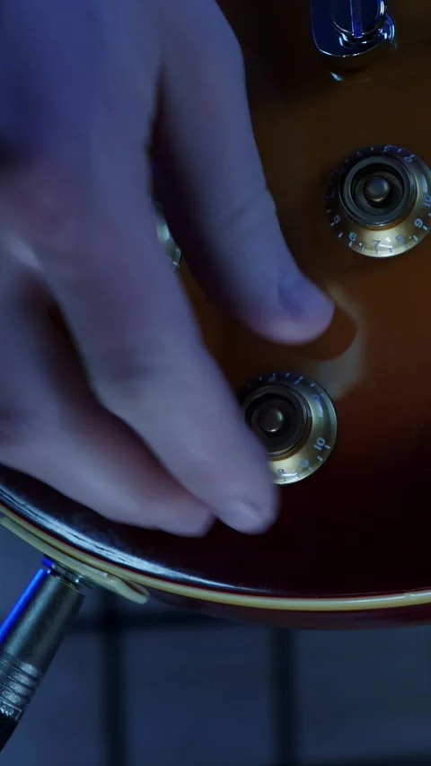 Turning volume and tone knobs on electric guitar at record studio.Vertical video 스톡 동영상 296742302