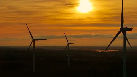 Turning windmills capturing breeze to generate renewable power. Spinning Stock Footage 319987961