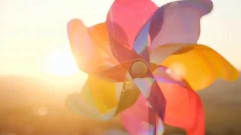 The turns color plastic pinwheel, windmill blowing a wind against the sunset sky Stock Footage